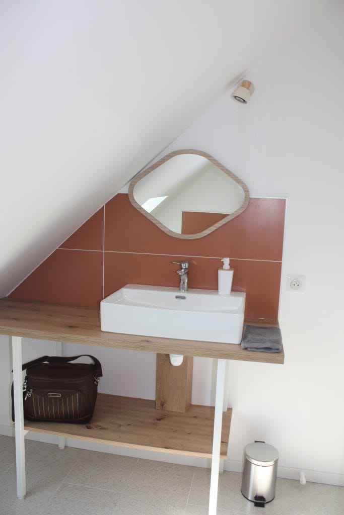 salle-d'eau-mansardée-de-couleur-terracota-avec-vasque-blanc-et-miroir-en-bois