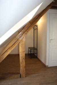 Portant-pour-vêtements-derrière-une-poutre-de-toit-parquet-au-sol