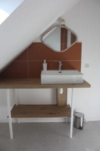 lavabo en porcelaine blanche robinet en inox avec faïence terracotta et miroir oval