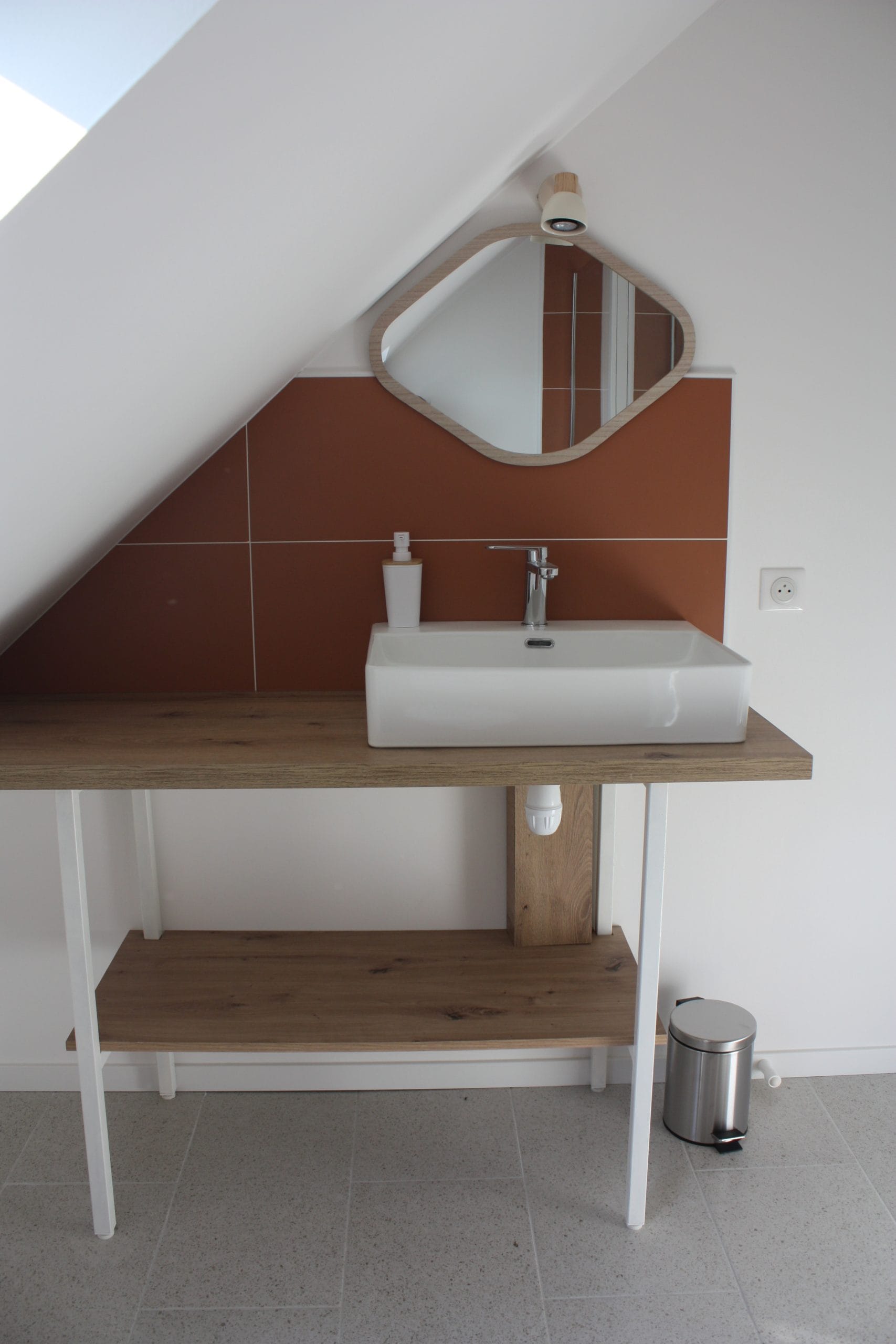lavabo en porcelaine blanche robinet en inox avec faïence terracotta et miroir oval