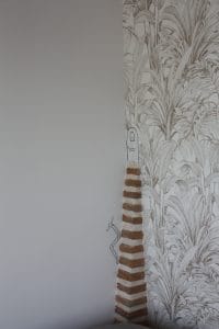 décoration-murale-faite-à-la-main-représentant-un-petit-lombric-humoristique-grimpant-une-petite-partie-de-la-cheminée-en-brique-pour-rentrer-dans-sa-maison