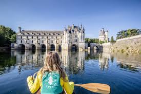 jeune fille en canoé sur le Cher avec vue sur le château de Chenonceau