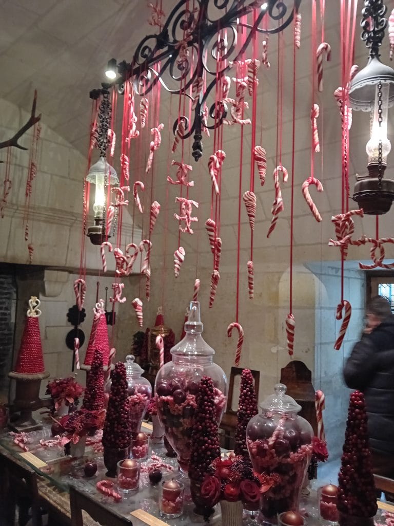 Décorations de Noël en sucre, style sucre d'orge, accrochée à un lustre au dessus d'une table remplie de confiserie de couleur rouge