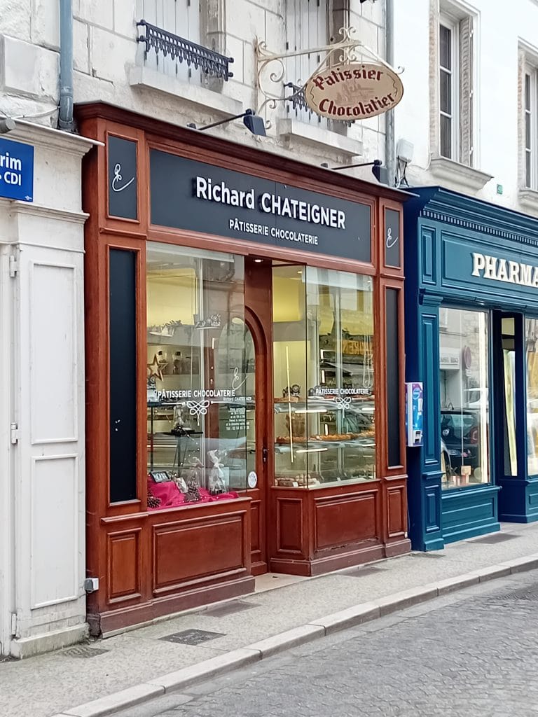 devanture d'une pâtisserie chocolaterie de couleur marron de centre ville avec ruelle pavée