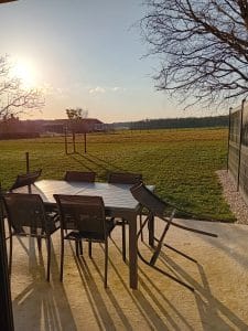 table et chaise de salon de jardin avec vue sur les champs et la forêt