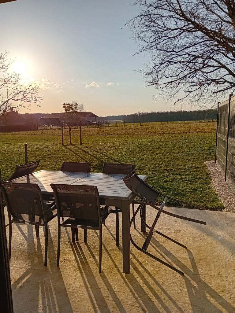 table et chaise de salon de jardin avec vue sur les champs et la forêt