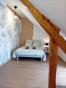 chambre avec lit double avec un conduit de cheminée en tête de lit