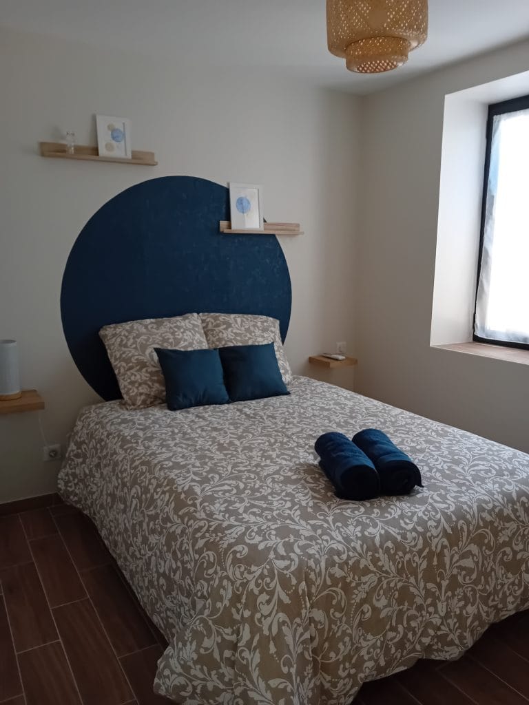 chambre dans les tons de beige et bleu avec un lit double