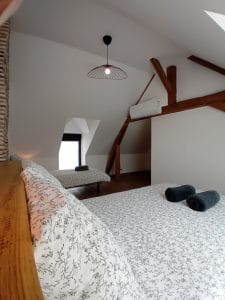 chambre avec lit double et lit simple avec poutre apparente