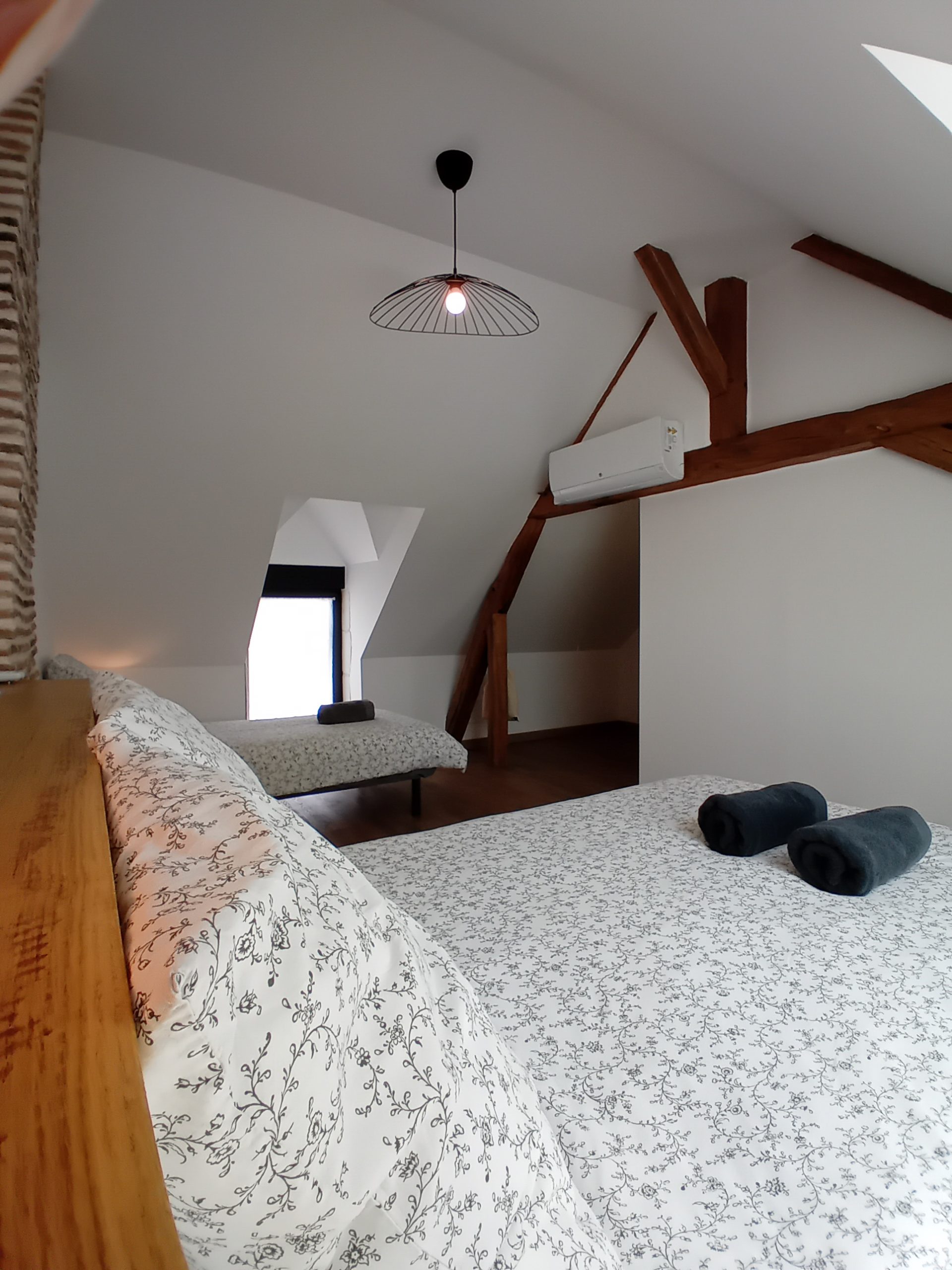 chambre avec lit double et lit simple avec poutre apparente