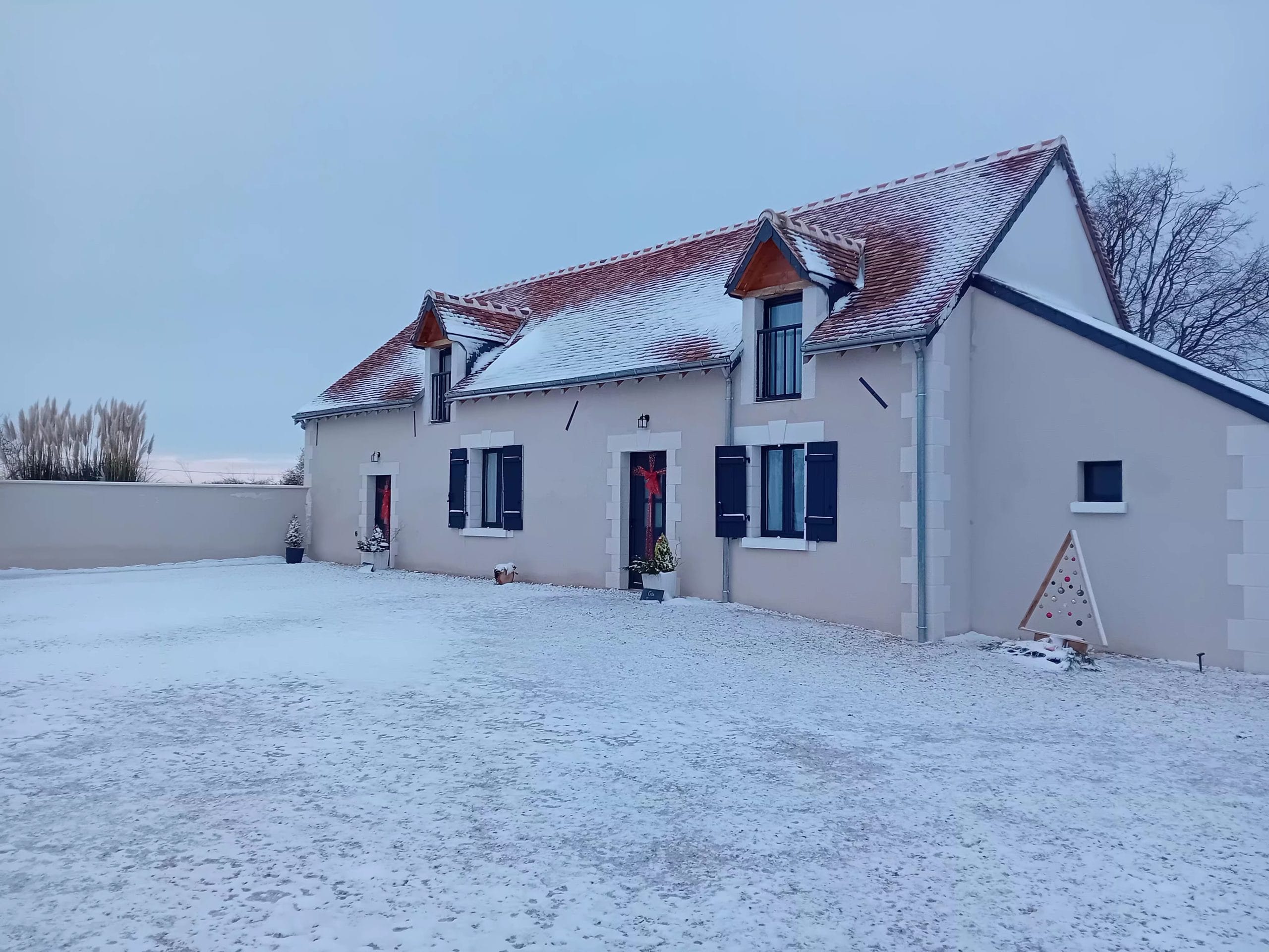 devant de la maison recouvert d'un petit tapis de neige avec décoration de Noël
